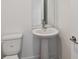 Modern half bathroom with white pedestal sink, toilet, and a large mirror on the wall at 1530 W River Shore Way, Tampa, FL 33603