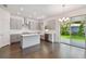 Modern kitchen with gray cabinets, island, stainless steel appliances, and sliding glass doors to backyard at 1530 W River Shore Way, Tampa, FL 33603