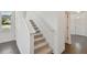 Carpeted staircase with white railing leading upstairs in a modern home at 1530 W River Shore Way, Tampa, FL 33603