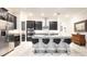 Modern kitchen with dark cabinetry, granite counters, and stainless steel appliances at 16831 Banner Shell Pl, Wimauma, FL 33598