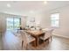 Bright dining area with wood table and chairs, opens to living room at 19231 Mossy Pine Dr, Tampa, FL 33647