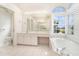 Bright bathroom featuring a large window bathing the tub in natural light at 5556 Sabal Trace Dr, North Port, FL 34287