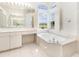 Bright bathroom featuring a soaking tub under a large window, enhancing the room's natural light and spacious feel at 5556 Sabal Trace Dr, North Port, FL 34287