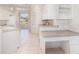 Bright kitchen with white cabinets, tile floor, and plenty of counter space, including a built-in desk area at 5556 Sabal Trace Dr, North Port, FL 34287
