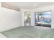 Open living room with tile flooring and lake view, seamlessly connecting to a sunlit kitchen and inviting pool area at 5556 Sabal Trace Dr, North Port, FL 34287