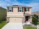 Charming two-story home with tan exterior, purple shutters, well-manicured lawn and inviting front entrance at 5808 Calla Lilly Dr, Sarasota, FL 34232