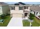 Inviting two-story home featuring a well-manicured lawn, complemented by a two-car garage and solar panels at 5808 Calla Lilly Dr, Sarasota, FL 34232