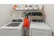 Laundry room with washer, dryer, and ample storage shelving at 5808 Calla Lilly Dr, Sarasota, FL 34232