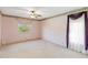 Empty bedroom with pink walls, carpet, a ceiling fan, and a window at 7853 Sundown Dr, St Petersburg, FL 33709