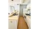 Efficient kitchen featuring white appliances and cabinets, tile backsplash, and a double stainless steel sink at 10024 Strafford Oak Ct # 815, Tampa, FL 33624