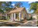 Charming yellow bungalow with a covered porch and well-manicured landscaping at 103 W Elm St, Tampa, FL 33604