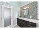 Modern bathroom featuring a sleek vanity, vessel sink, and stylish mosaic tile accent wall at 123 8Th E St, Tierra Verde, FL 33715