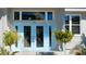 Home's bright blue front door, large windows and clean landscaping at 123 8Th E St, Tierra Verde, FL 33715
