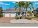 Beautiful single-Gathering home with a two-car garage, blue front doors, and tropical landscaping at 123 8Th E St, Tierra Verde, FL 33715