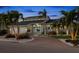 Modern home showcasing a grand entrance, lush landscaping, and circular brick driveway at 123 8Th E St, Tierra Verde, FL 33715