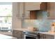 Close up of kitchen details including wood cabinets, tile backsplash, stainless oven, and quartz countertops at 123 8Th E St, Tierra Verde, FL 33715