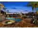 Backyard pool and jacuzzi with brick patio and waterfront views at twilight at 123 8Th E St, Tierra Verde, FL 33715
