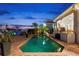 Backyard pool and patio area with outdoor seating and lush landscaping at twilight at 123 8Th E St, Tierra Verde, FL 33715