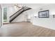Spacious living room with hardwood floors, a ceiling fan, and a modern staircase at 1328 Pelican Creek Xing # D, St Petersburg, FL 33707