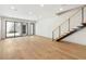 Bright, open-concept living area with hardwood floors, modern staircase, and sliding glass doors at 1412 S Moody Ave # A, Tampa, FL 33629