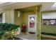 Front entryway features a red door, decorative metalwork, and festive decorations at 1521 San Helen Dr, Dunedin, FL 34698