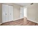 Simple bedroom with wood-look floors and mirrored closet doors at 1799 N Highland Ave # 28, Clearwater, FL 33755