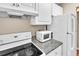 Efficient kitchen with white cabinets, granite counters, and appliances at 1799 N Highland Ave # 28, Clearwater, FL 33755