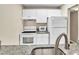 Clean kitchen featuring white cabinets, granite countertops, and modern appliances at 1799 N Highland Ave # 28, Clearwater, FL 33755