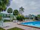 Community pool and patio with palm trees and lounge chairs at 1799 N Highland Ave # 28, Clearwater, FL 33755