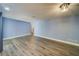 Spacious living room featuring light blue walls and wood-look flooring at 1815 Elmhurst Dr, Clearwater, FL 33765