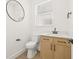 Small bathroom with light wood vanity, black fixtures, and modern circular mirror at 3006 E Columbus Dr, Tampa, FL 33605