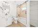 Modern bathroom with white vanity, black fixtures, tub/shower, and wood-look tile at 3006 E Columbus Dr, Tampa, FL 33605