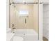 Bathroom with tub/shower, glass door, black fixtures, and wood-look tile at 3006 E Columbus Dr, Tampa, FL 33605