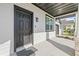 Welcoming front entry with a black door, a welcome mat, and a covered porch at 3006 E Columbus Dr, Tampa, FL 33605