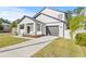 White two-story house with a covered porch, landscaping, a driveway, and a fenced yard at 3006 E Columbus Dr, Tampa, FL 33605