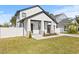 Inviting front exterior of a white house with a covered porch, landscaping, and a fenced yard at 3006 E Columbus Dr, Tampa, FL 33605
