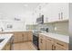 Updated kitchen with stainless steel appliances, marble counters, and light green tile backsplash at 3006 E Columbus Dr, Tampa, FL 33605