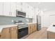 Sleek kitchen with stainless steel appliances, light wood cabinets, and white countertops at 3006 E Columbus Dr, Tampa, FL 33605