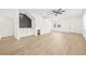 Bright and airy living room with wood floors, white walls, a ceiling fan, and a built-in wet bar at 3006 E Columbus Dr, Tampa, FL 33605