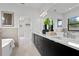 Sleek bathroom with dark wood vanity, dual sinks, and a view of the walk-in closet at 432 43Rd Ne Ave, St Petersburg, FL 33703