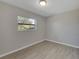 Empty bedroom with neutral gray walls, wood-look flooring, and a large window at 527 Fox Run Trl, Apollo Beach, FL 33572