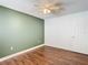 Bedroom with wood floors, one wall painted green at 6371 Shadydale Ave, Spring Hill, FL 34609