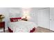 Simple bedroom with a red and white quilt at 6760 Burning Tree Dr, Seminole, FL 33777