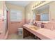 Pink bathroom with a vanity, toilet, and shower/tub combo at 8020 Coquina Way, St Pete Beach, FL 33706