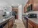 Modern kitchen with dark wood cabinets, granite counters, and black appliances at 10119 Rose Petal Pl, Riverview, FL 33578