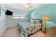 Bedroom with light green walls, a queen-size bed with a tropical-themed comforter, and carpeted floors at 10600 Orange Blossom Ln, Seminole, FL 33772