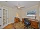 Bright home office featuring a wooden desk, ergonomic chair, and French doors at 1154 Commodore St, Clearwater, FL 33755