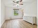 Bright bedroom with wood-look floors, ceiling fan, and a large window at 13682 Orange Sunset Dr # 102, Tampa, FL 33618