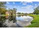 Community Pond with tree lined shore at 13682 Orange Sunset Dr # 102, Tampa, FL 33618