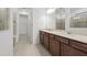 Bright bathroom featuring dual sinks, a large mirror, and a walk-in shower at 3065 Winding Creek Trl, North Port, FL 34289